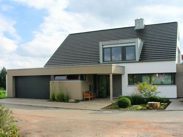 Wohnhaus mit ebenen Tonziegeln Gauben mit Stehfalz aus Titanzink