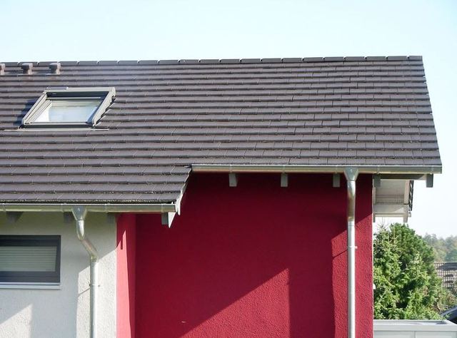 Modernes Wohnhaus mit ebener Tonziegeleindeckung und Titanzinkarbeiten an Carport