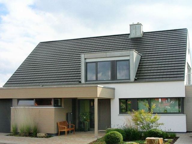 Wohnhaus mit ebenen Tonziegeln Gauben mit Stehfalz aus Titanzink