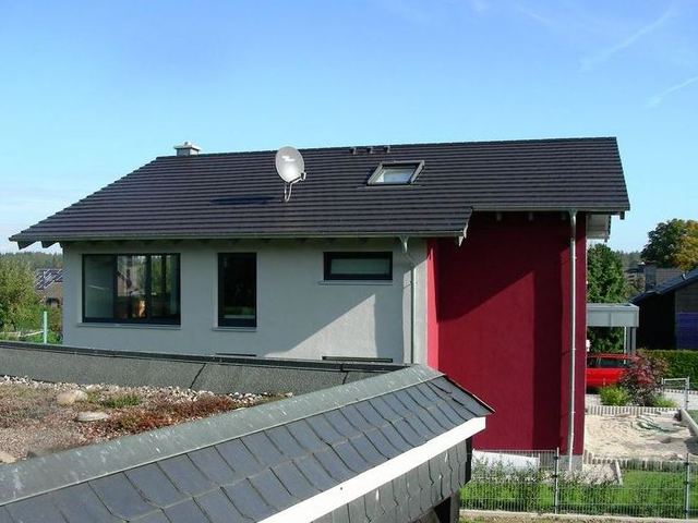 Modernes Wohnhaus mit ebener Tonziegeleindeckung und Titanzinkarbeiten an Carport