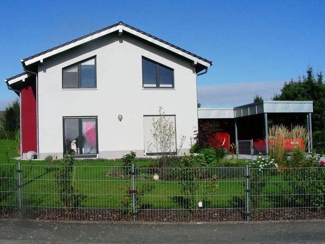 Modernes Wohnhaus mit ebener Tonziegeleindeckung und Titanzinkarbeiten an Carport